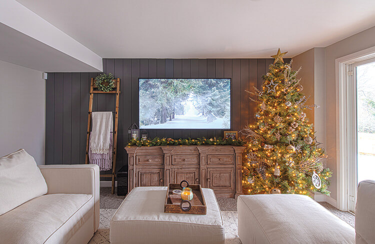 media room with natural colored tree and garland on media console