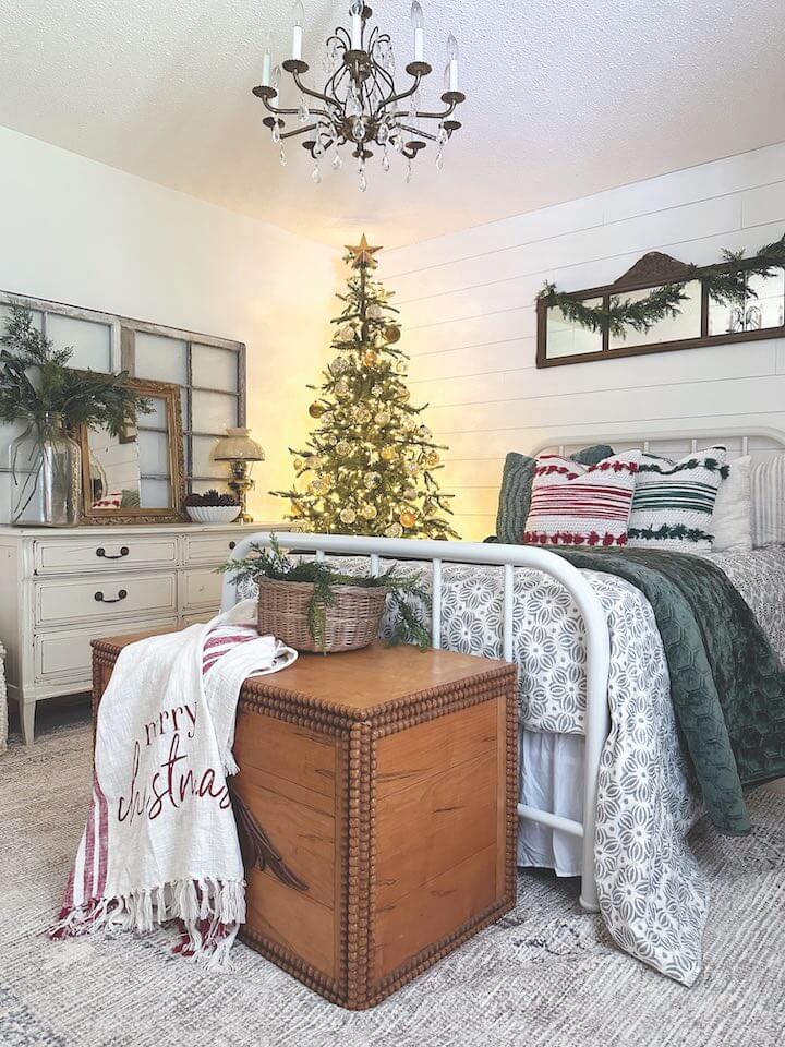 holiday guest bedroom with layered bedding and Christmas tree