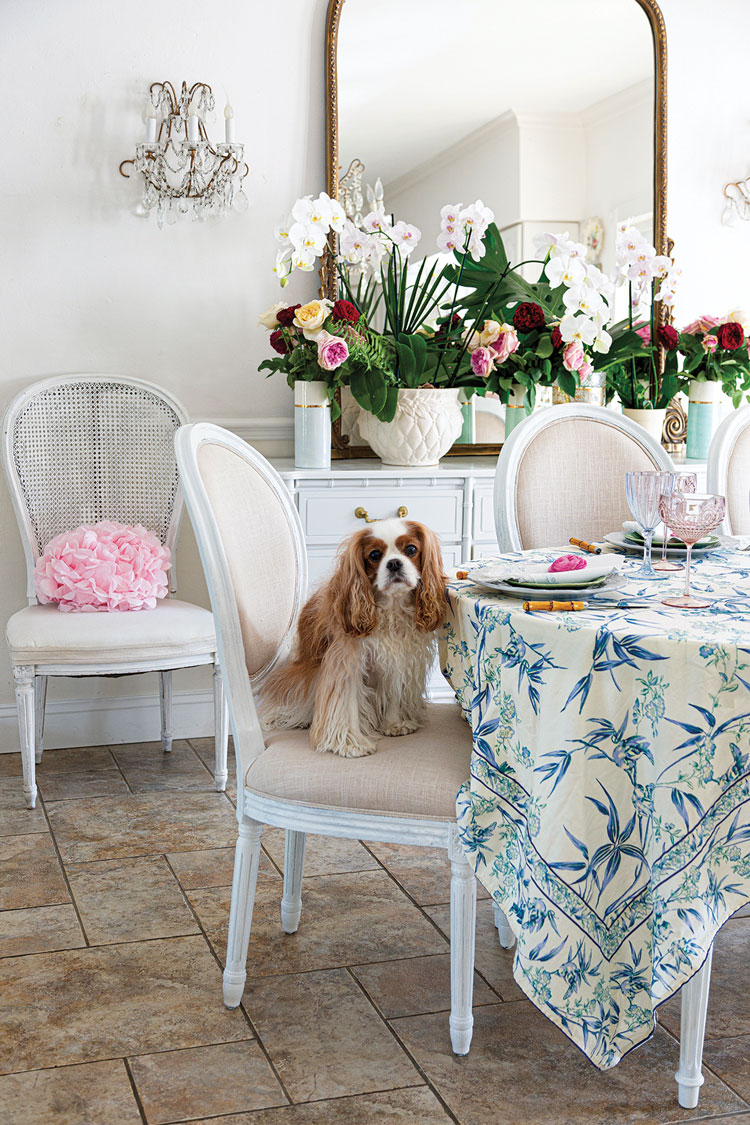 floral arrangements and blue and white floral tablecloth in vintage farmhouse elegant dining room in Florida home