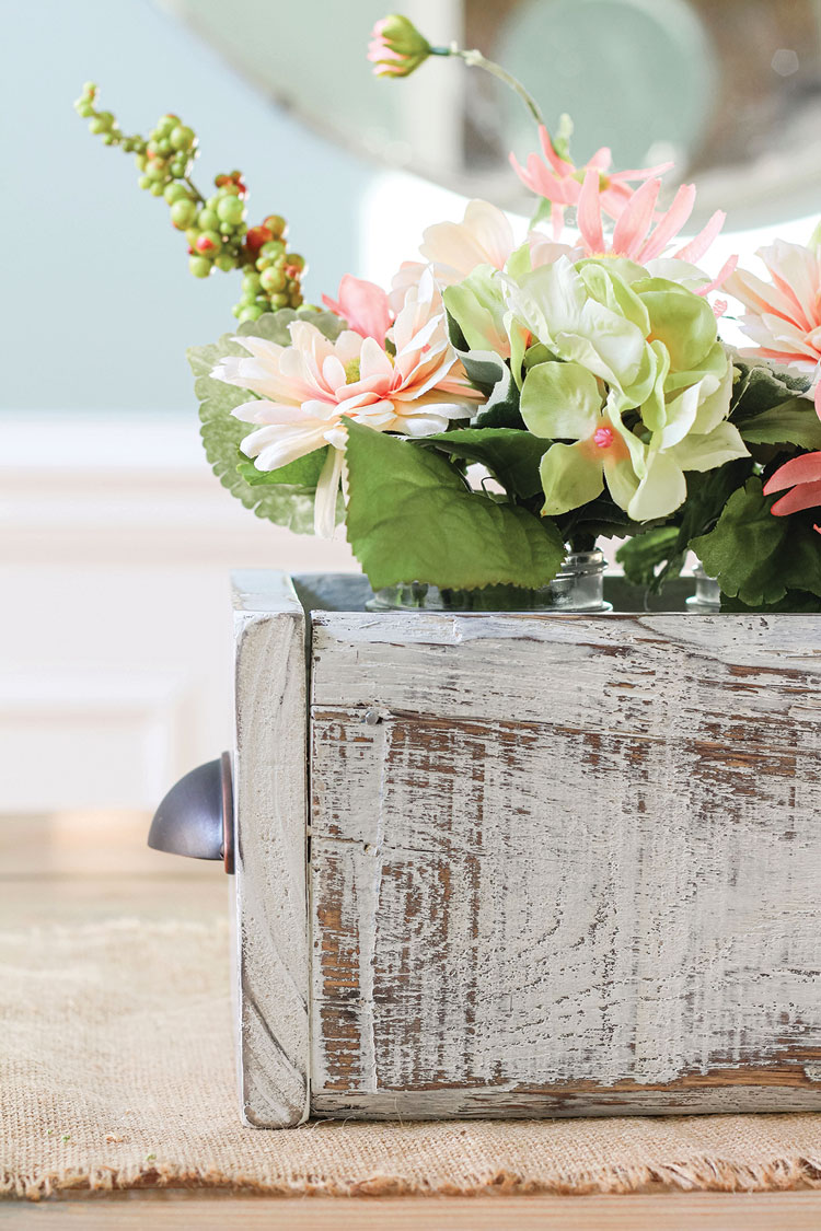 completed wooden box in use as farmhouse table centerpiece housing flower arrangements