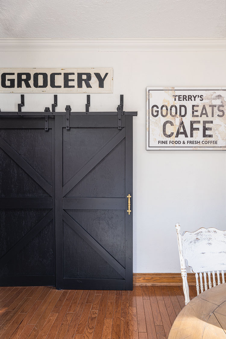 sliding barn door and vintage signs in farmhouse kitchen