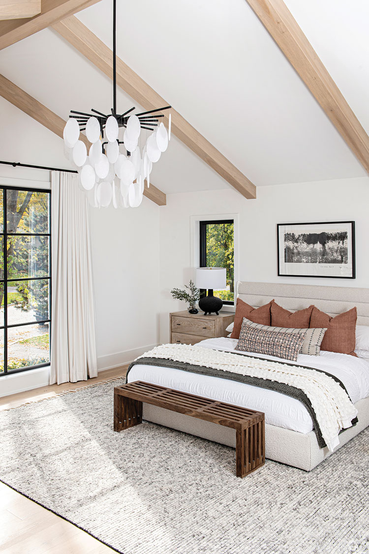 master bedroom with modern chandelier and exposed wood beams in Ontario home