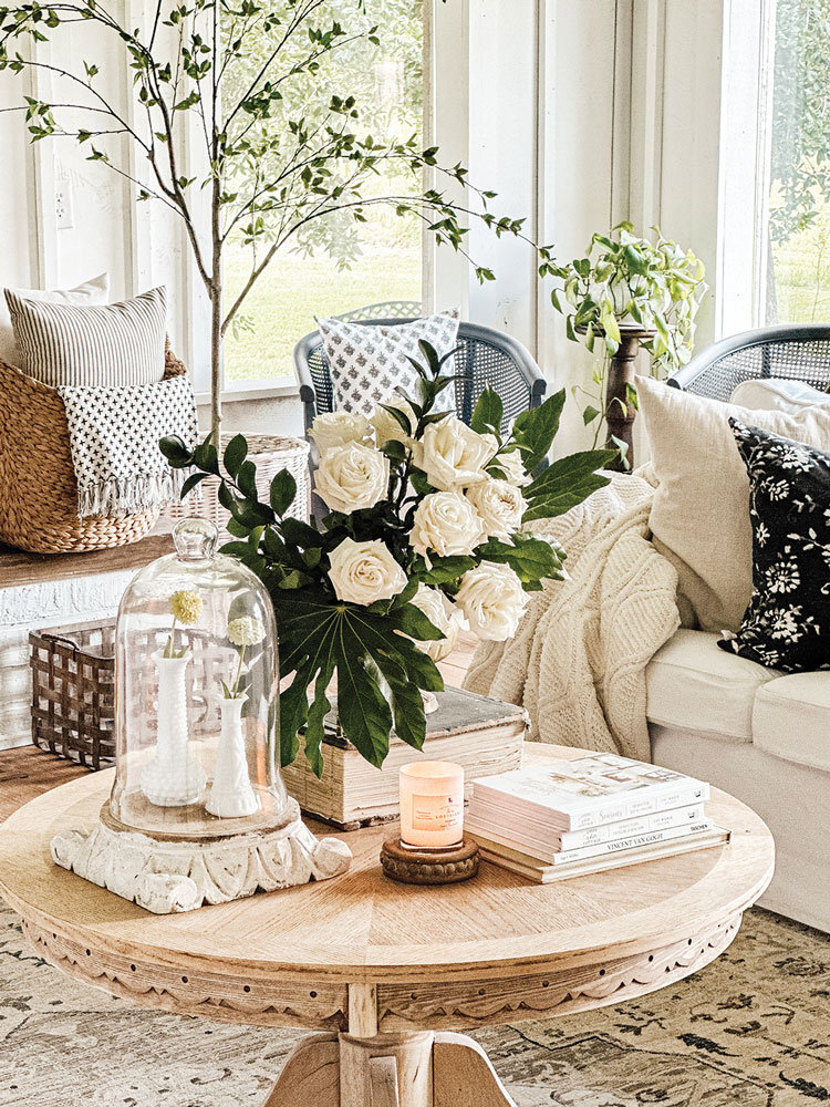 white vignette with roses and cloche on wood coffee table