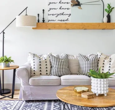 boho farmhouse living room with geometric rug and throw pillows and wood furniture