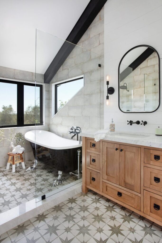 starburst patterned tile with high contrast black clawfoot tub and angled ceiling beam