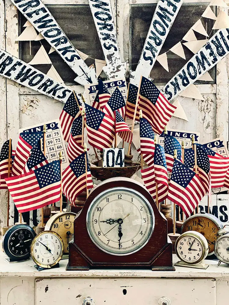 collection of vintage clocks surrounded by small US flags