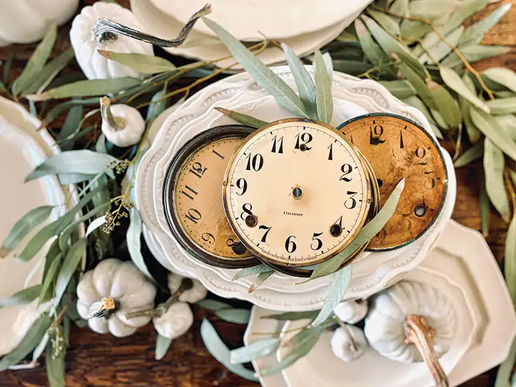 vintage clocks as part of table setting with bay leaves and white gourds