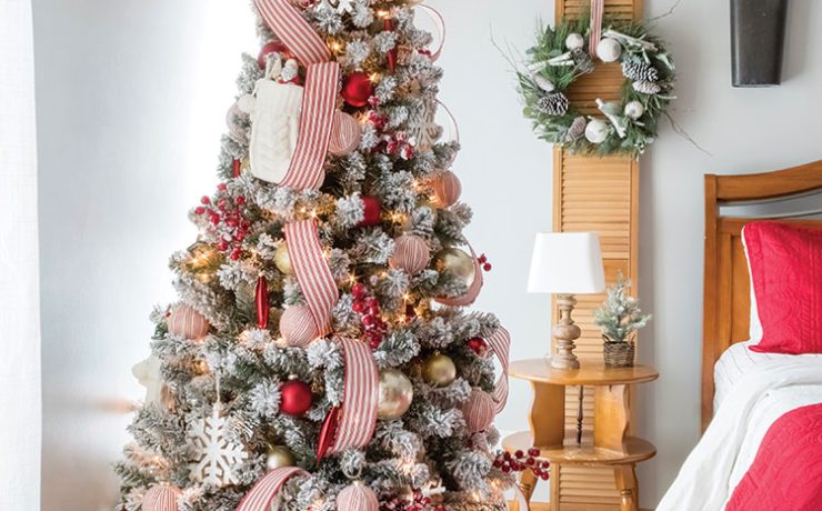 Christmas tree in bedroom features red and white striped ribbon