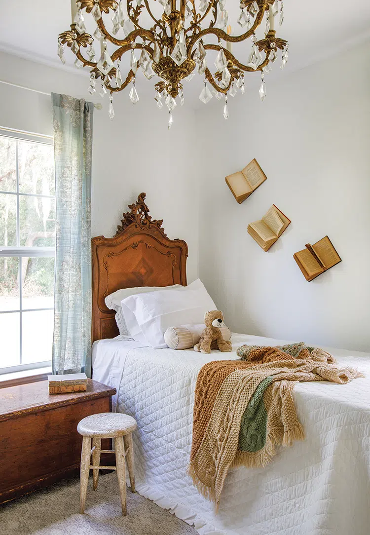 girl's room with vintage books as decor and bedframe with vintage headboard