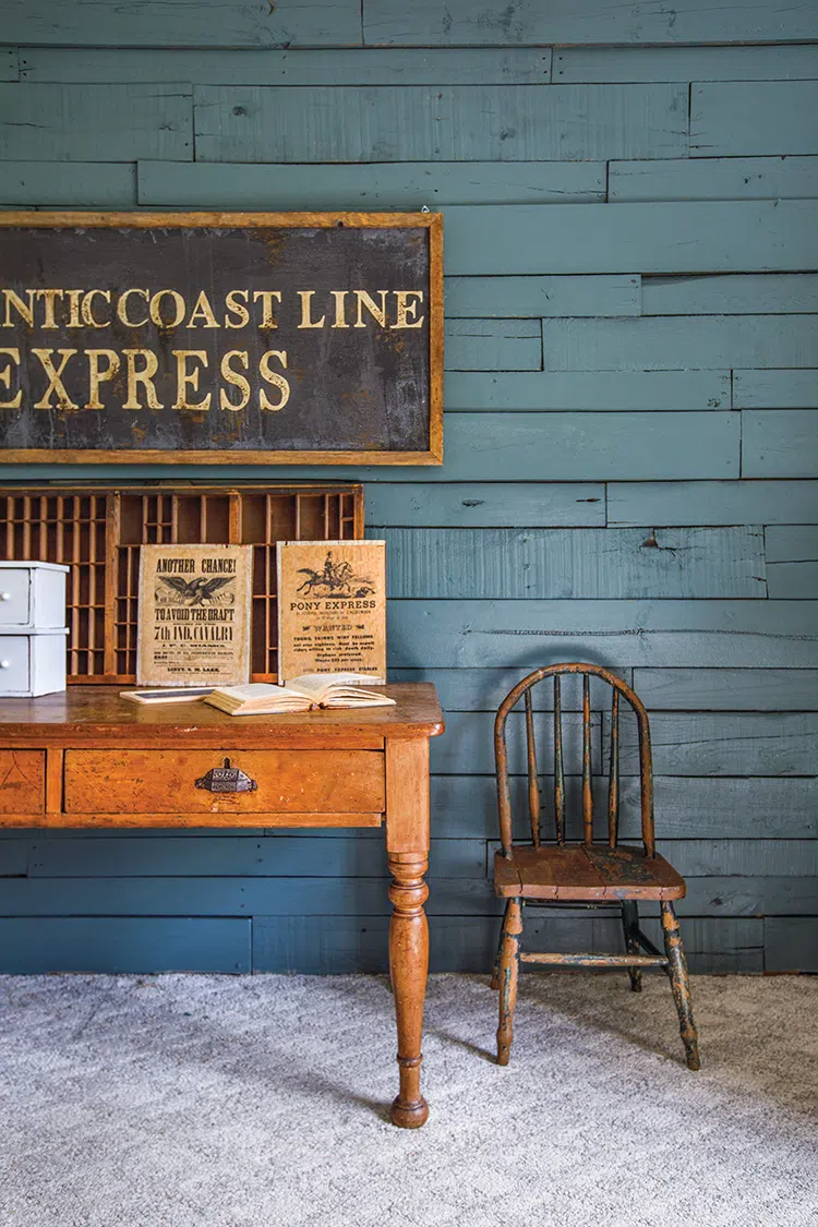 desk with vintage sign above on blue shiplap wall