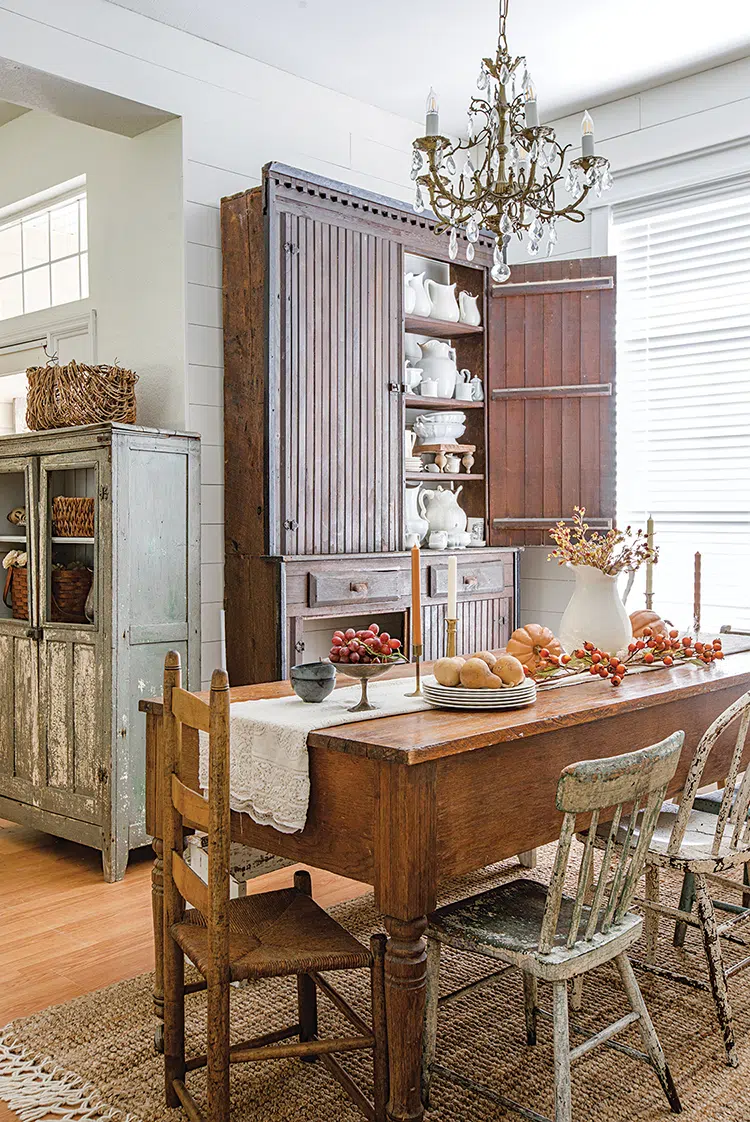 vintage furniture in dining room decorated for fall with gourds and pumpkins along table runner of dining table