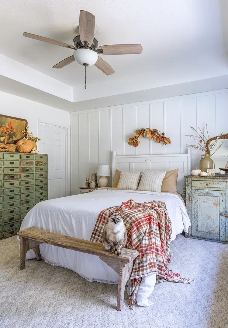 fall bedroom with white walls and patina cabinets and natural fall decor