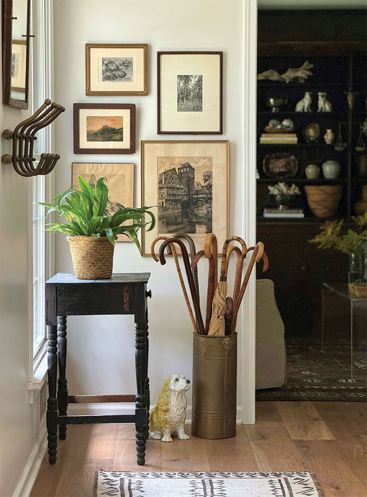 gallery wall in entryway with collection of wooden canes and umbrellas