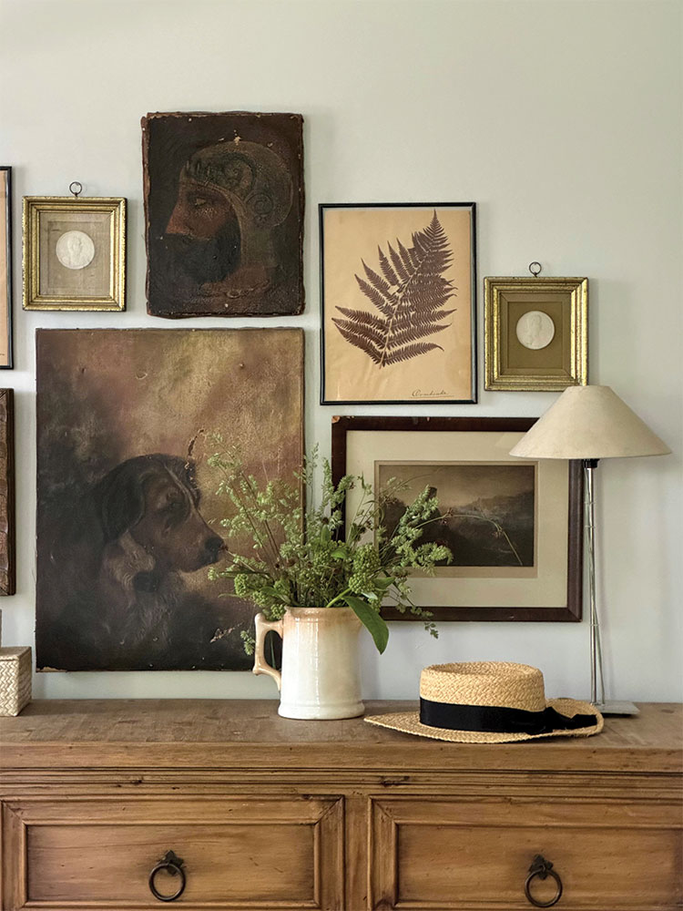 gallery wall with neutral art above dresser in bedroom