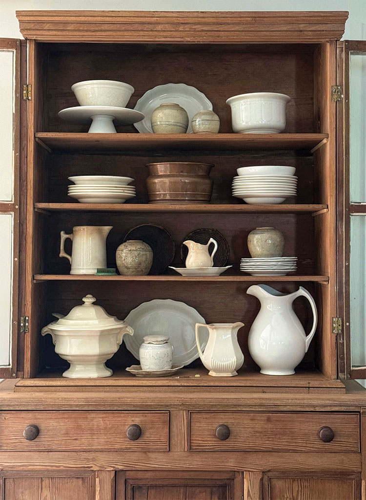 collection of vintage ironstone in wooden hutch