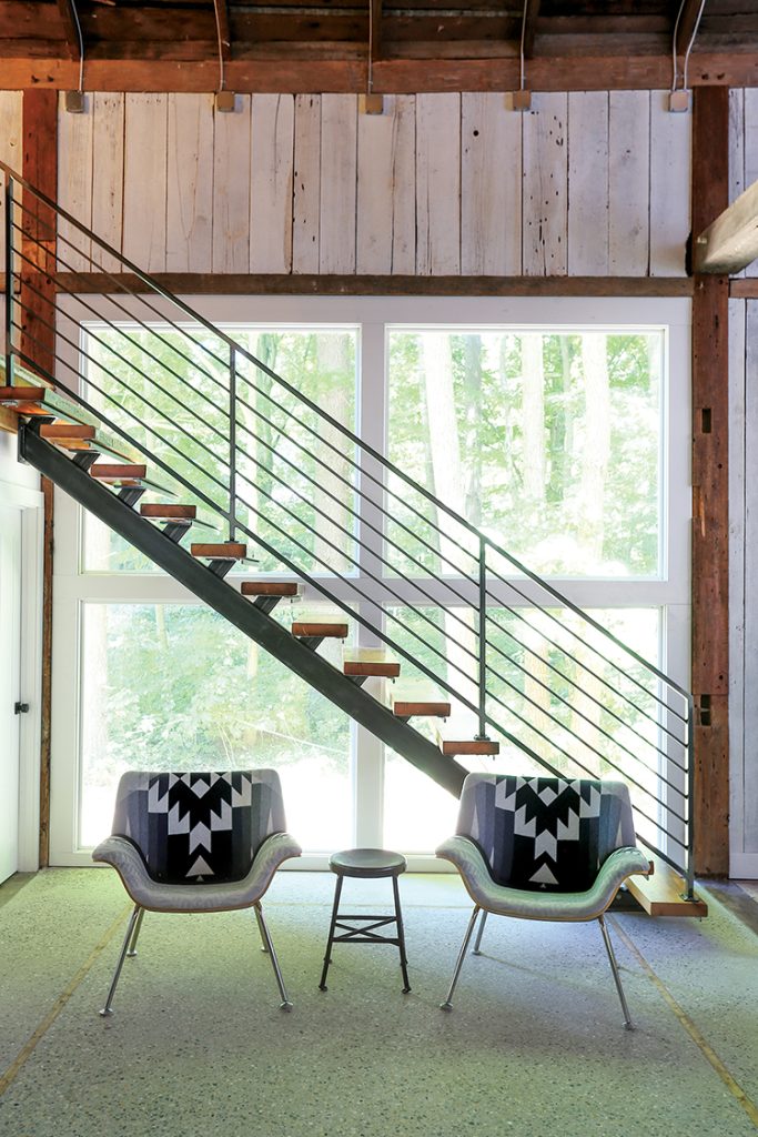 renovated barn vacation home with metal stair railing and wooden floating stairs