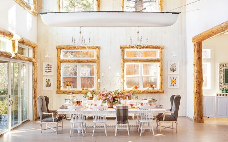 farmhouse cabin in Big Bear features flowers wooden window frames and chandeliers hanging from old canoe