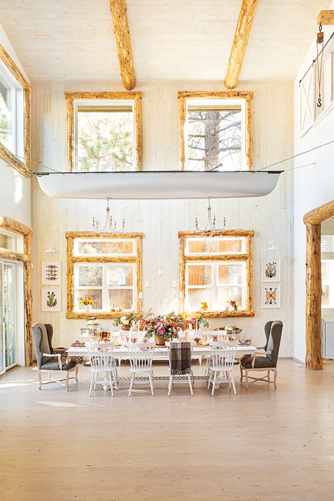 Big Bear cabin dining room with log accents farmhouse table and canoe mounted above