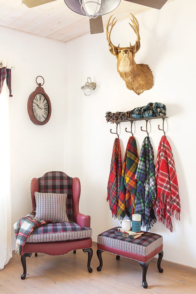 plaid throws handing from wall hooks and deer head mounted on the wall in Big Bear farmhouse cabin