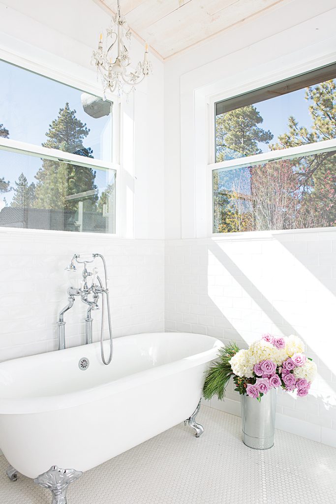 hexagonal tile, clawfoot tub and small chandelier in Big Bear cabin bathroom