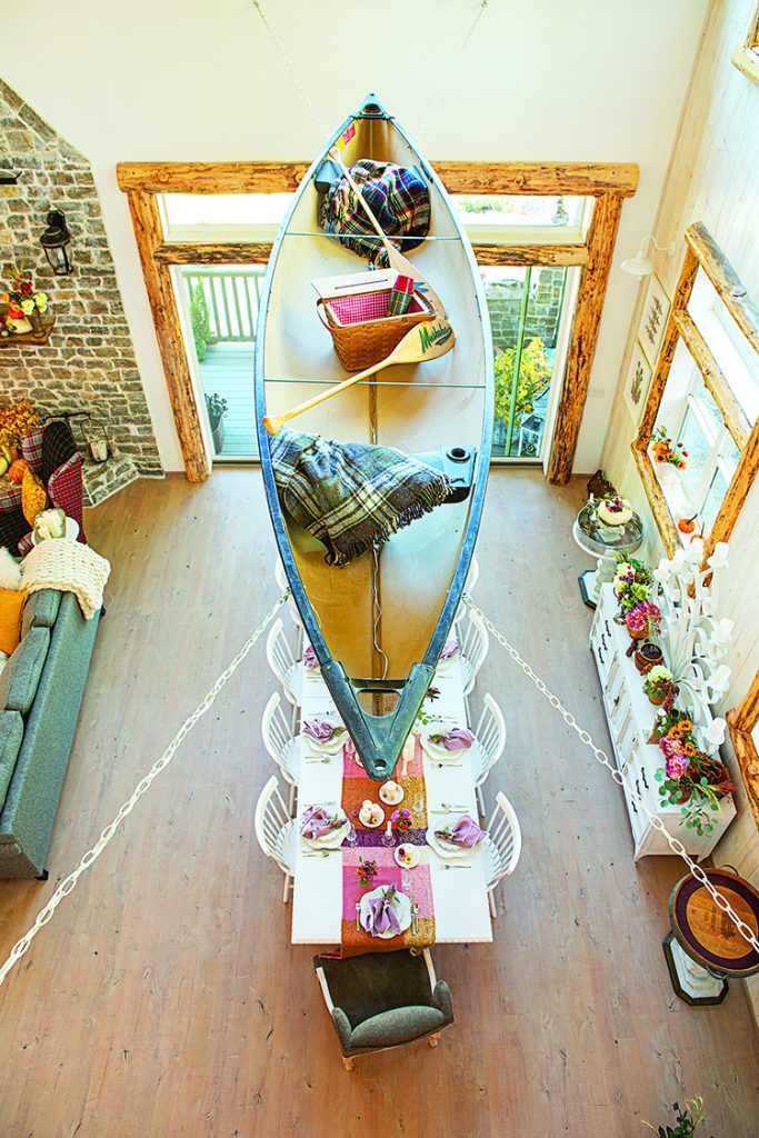 aerial view of canoe handing above the dining room and containing vintage collectibles