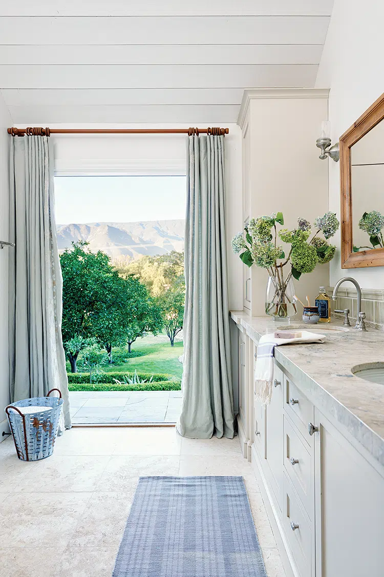 master bathroom with grays and blue accents and view to trees and mountains