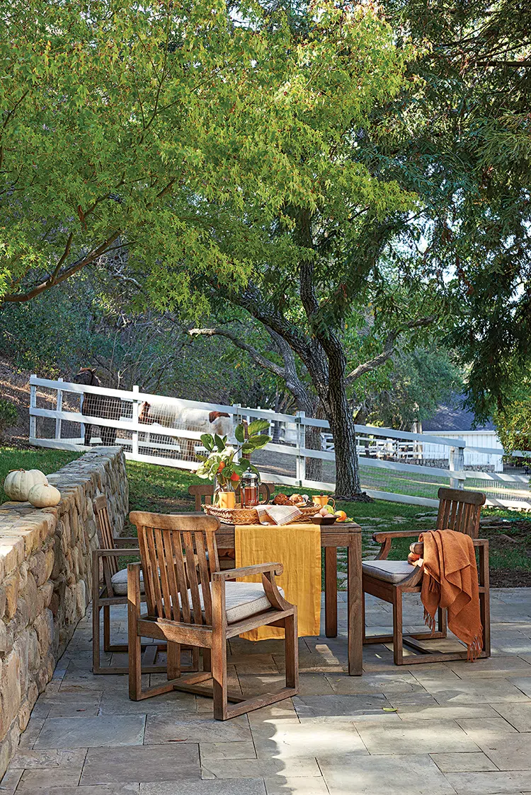 outdoor dining area with white pumpkins and apples and view to barn outside master bedroom of authentic farmhouse in Ojai