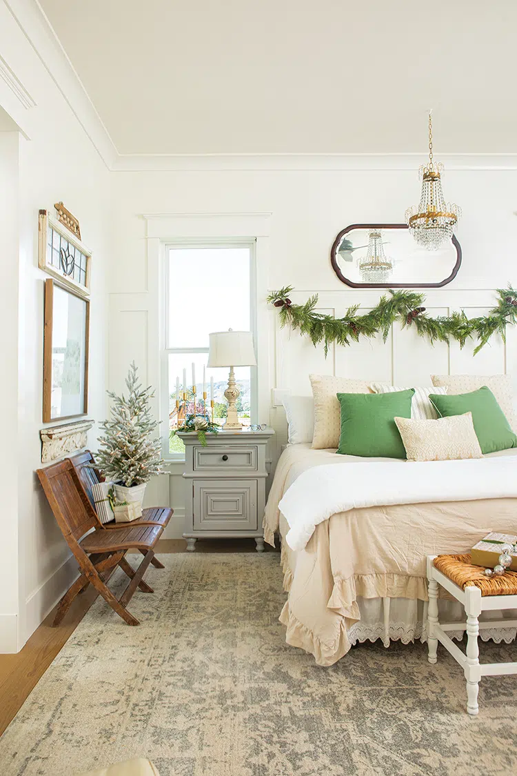 bedroom at Christmastime with cedar garland on headboard and small potted tree