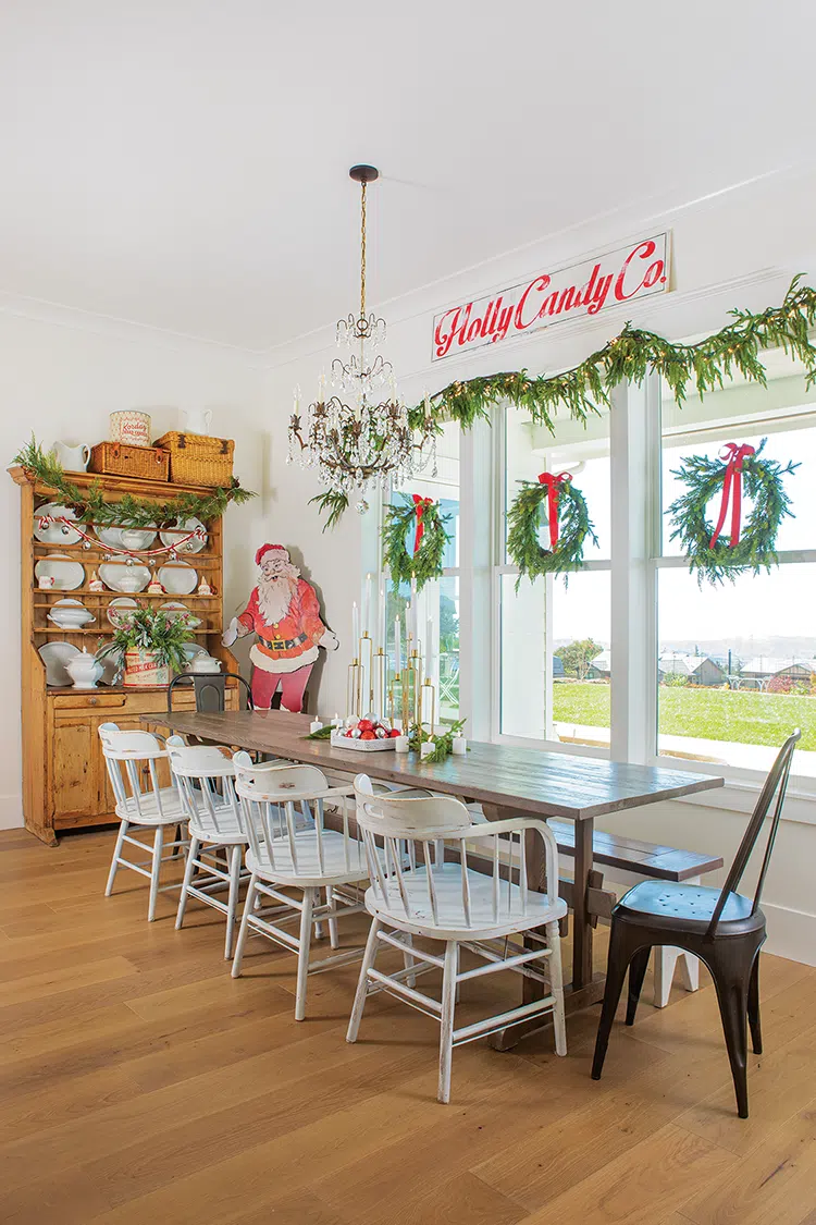 vintage sign and Santa cutout in dining room with wreaths in each window