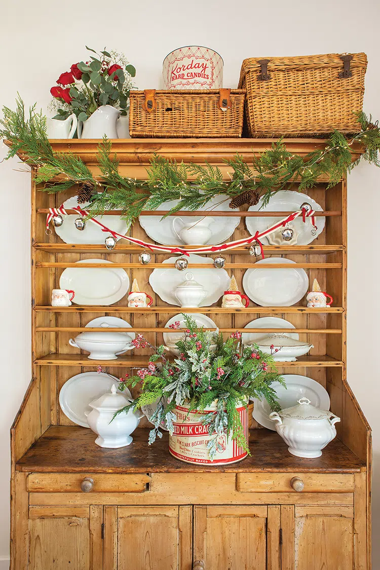 hutch with vintage Santa mugs and ironstone with natural garland