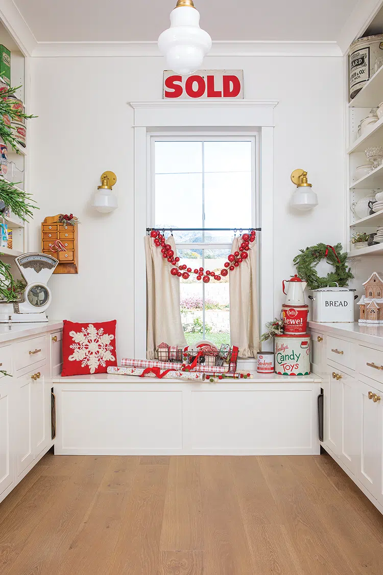 red bells and throw pillow on bench seating in vintage home at Christmastime