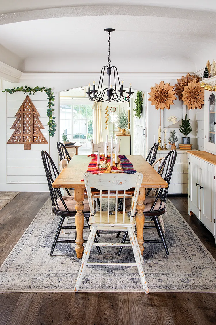 dining room with handmade snowflakes and colorful table runner on farmhouse style table