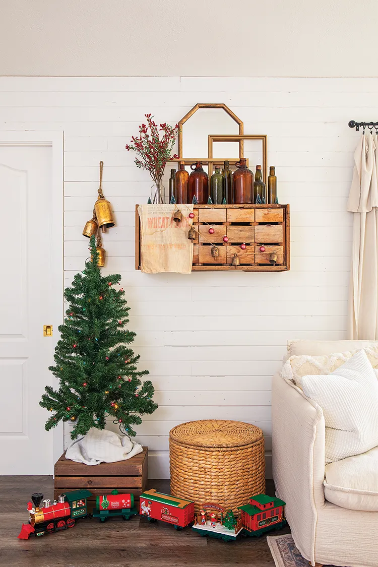 small Christmas tree on top of wooden crate with vintage style train at the bottom