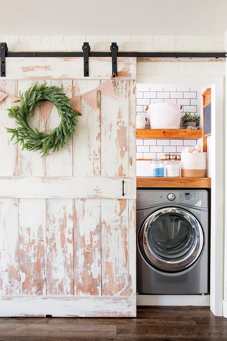 sliding barn door with natural wreath and red and white striped pennants