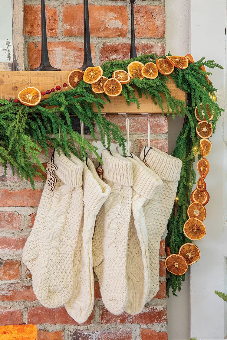 cable knit white stocking and pine wreath with dried citrus rounds