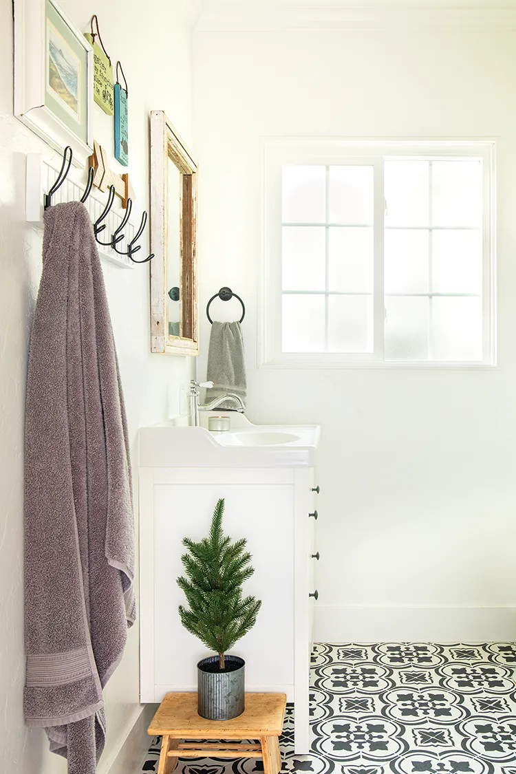 vintage white bathroom with black accents and small potted tree for Christmas