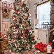 Christmas tree with red and white presents underneath and basket of red poinsettias