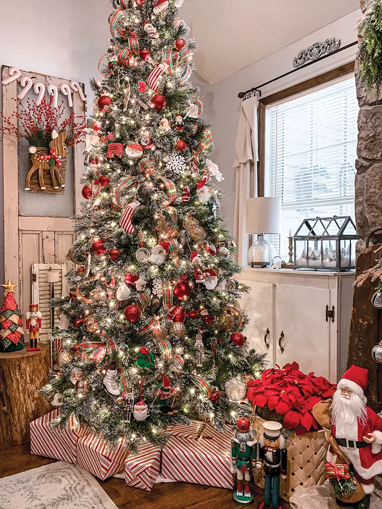 Christmas tree with red and white presents underneath and basket of red poinsettias