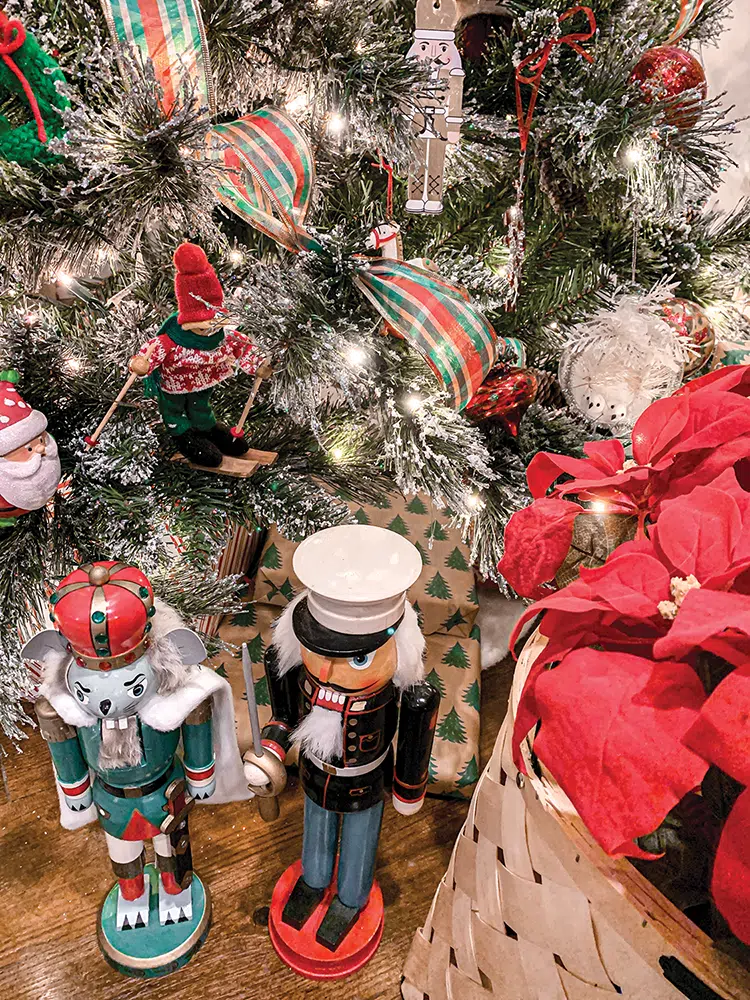 winning Christmas tree with red and green ribbon and wooden nutcrackers at the base