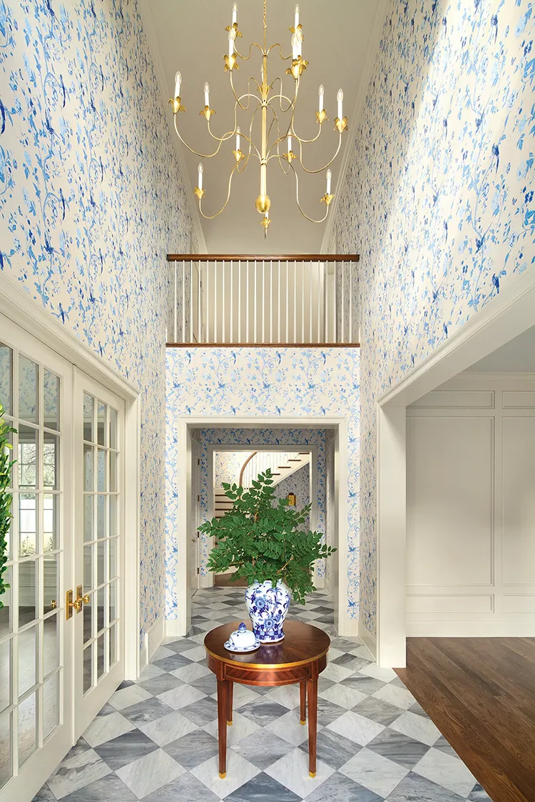 Project House Utah entryway with big chandelier and white and blue wallpaper