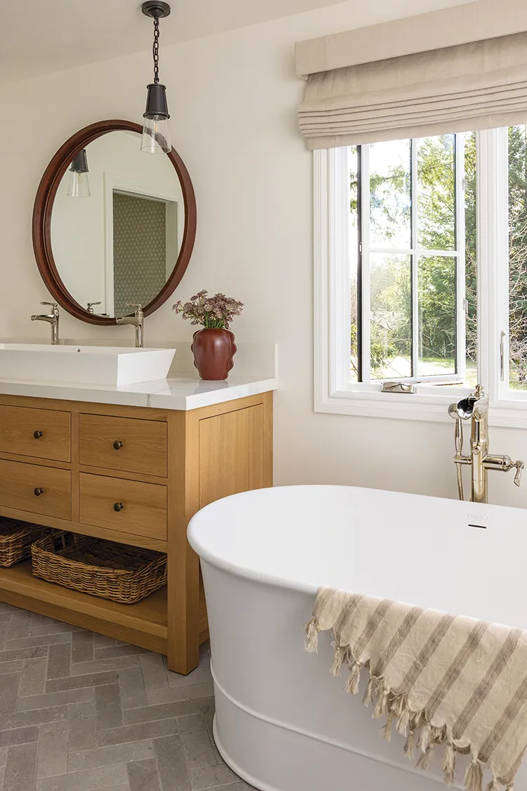 soaking tub in neutral modern farmhouse bathroom