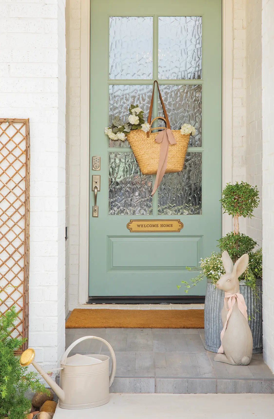 front porch of new build farm cottage with spring green door and rabbit sculpture