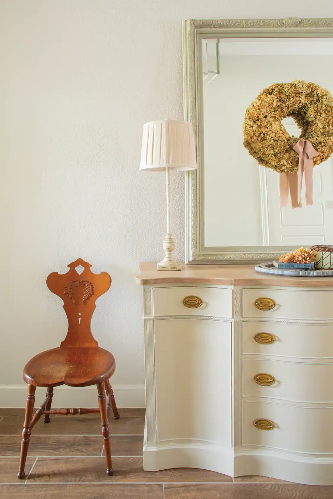 dried hydrangea wreath and antique chair in new build farm cottage