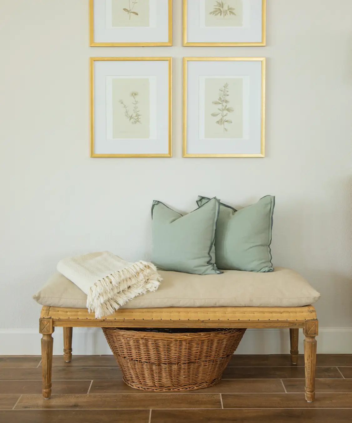 new build cottage with framed botanical prints above wooden entryway bench