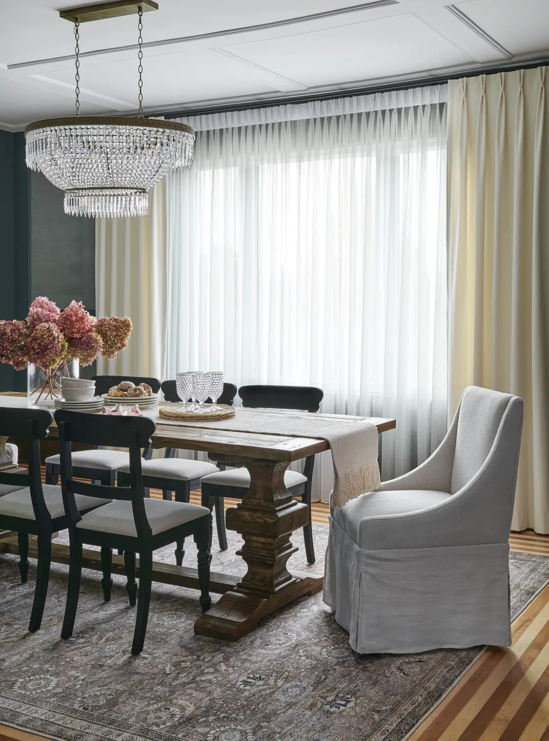 dining room with cream and sheer curtains, chandelier and dried hydrangeas