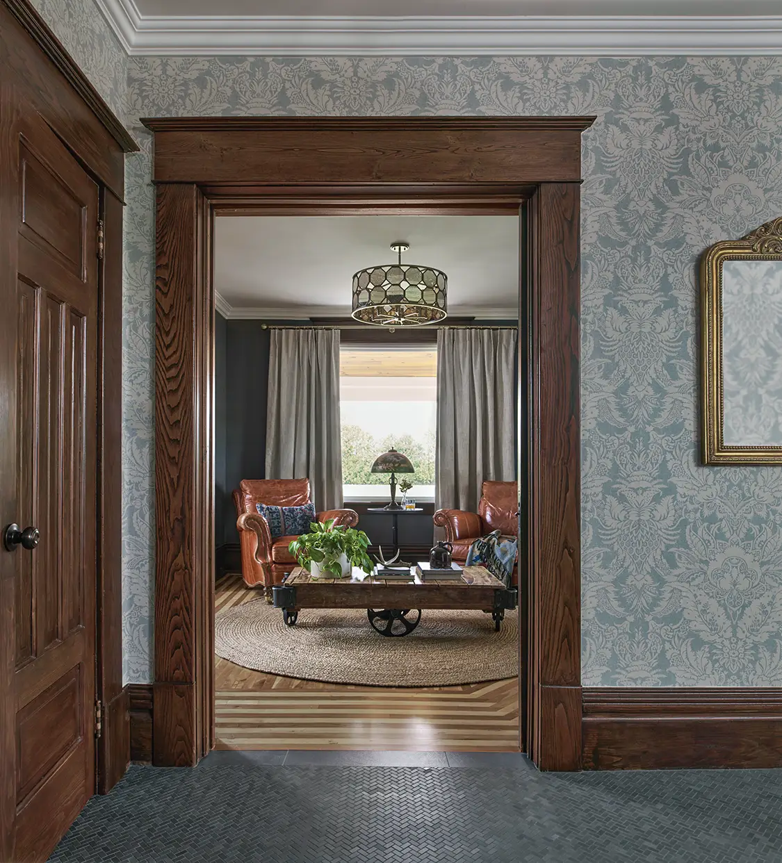 view to living room with leather reading chairs and antique roller coffee table