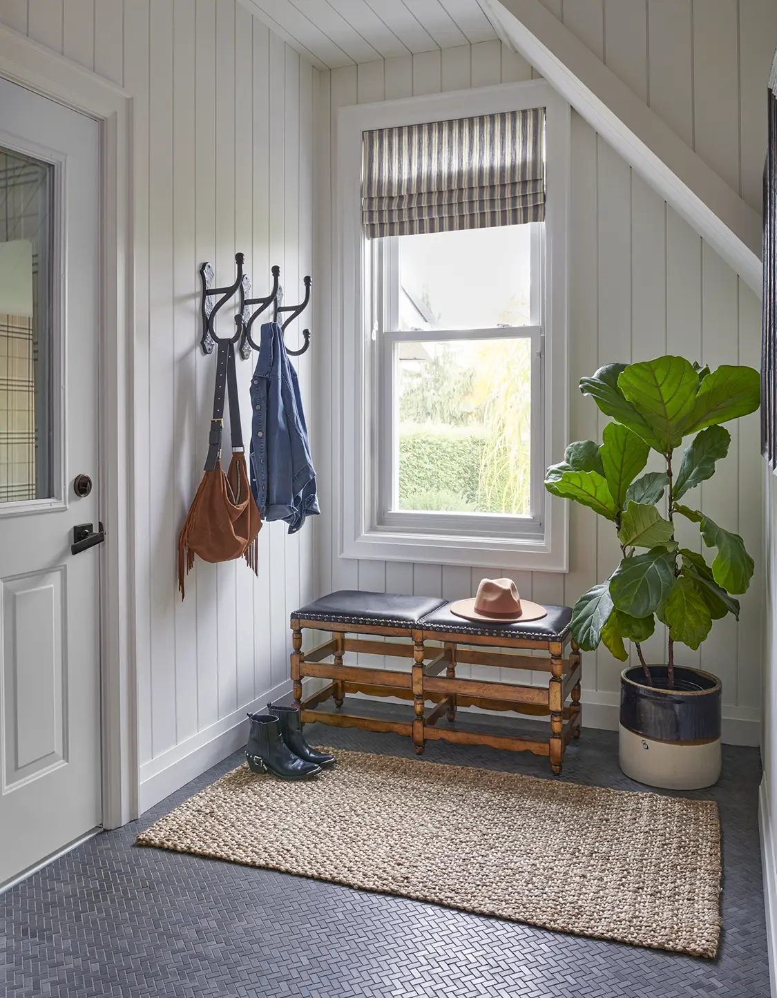 fiddle leaf fig by entryway bench and herringbone tile floor