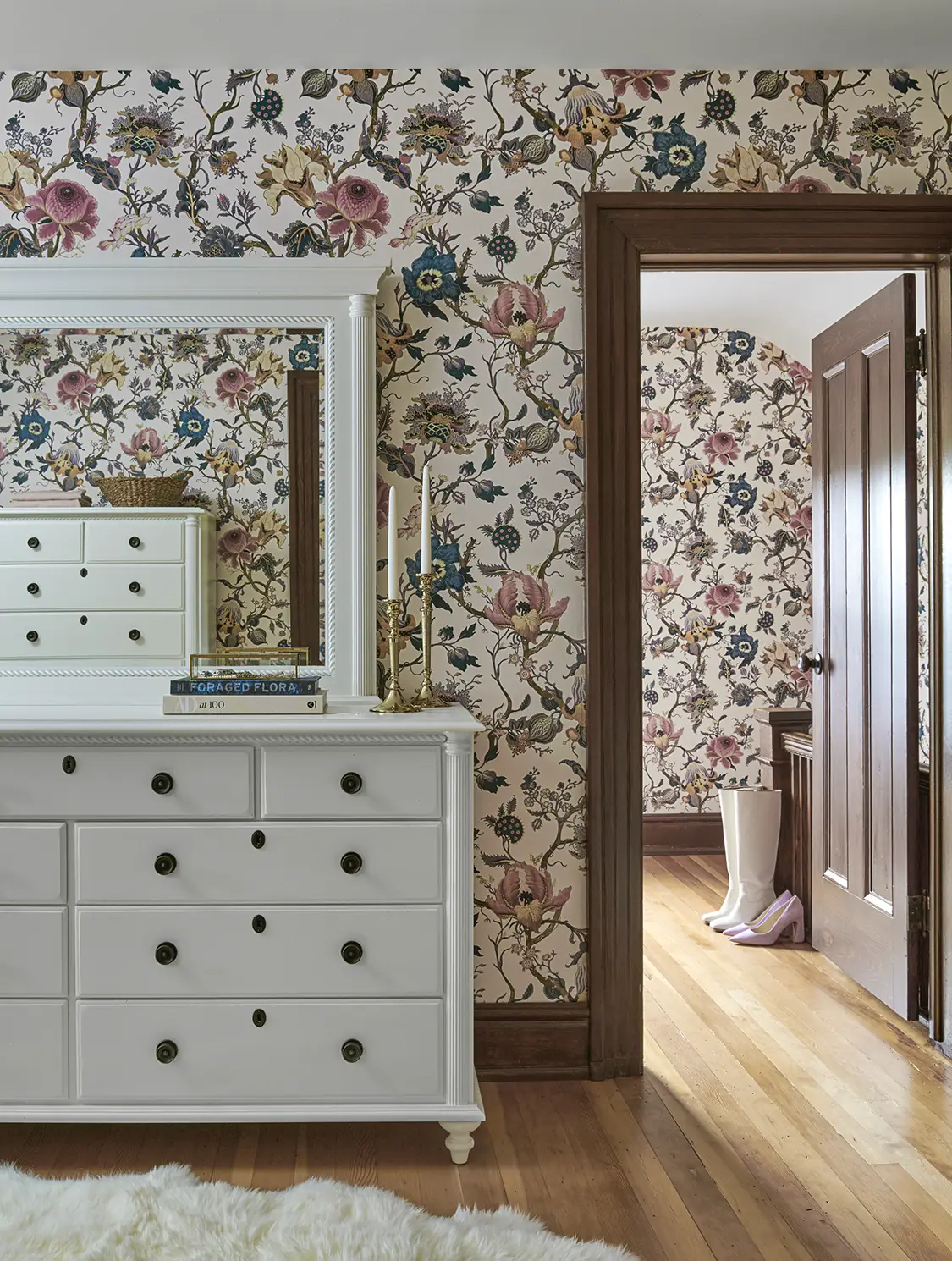 floral wallpaper in bedroom with white dresser with built-in mirror