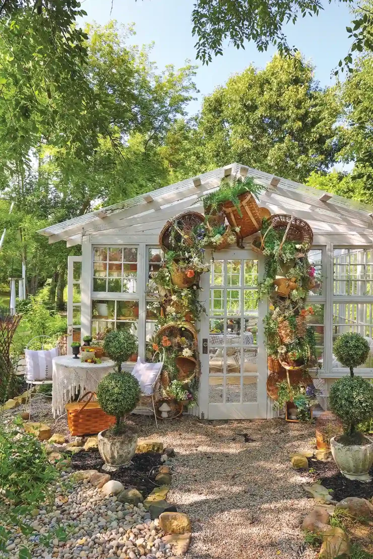 baskets with flowers surround the doorway of greenhouse on Michigan home property