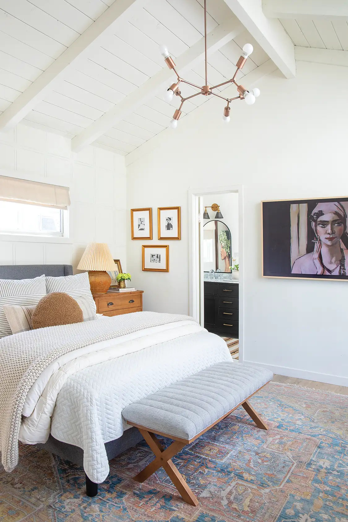 Sputnik style chandelier and gramed art in bedroom with high vaulted ceilings